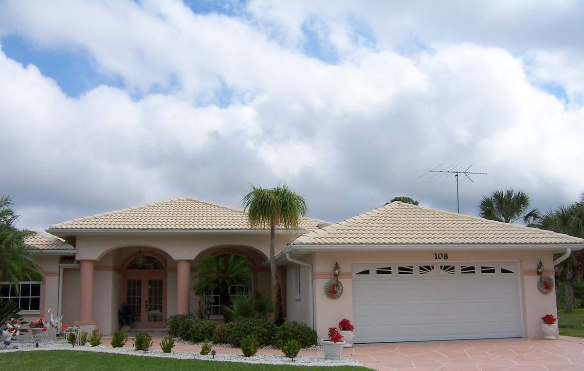 The same Florida home after cleaning, with a bright tile roof and clean stucco